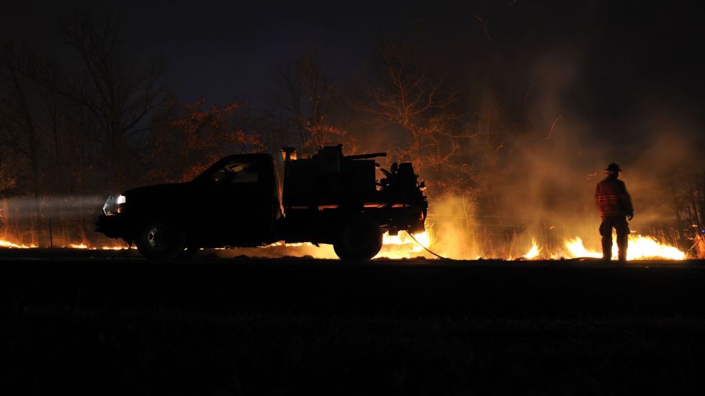 firefighter works to put out wildfire
